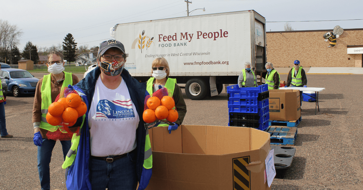 people in front of truck holding oranges