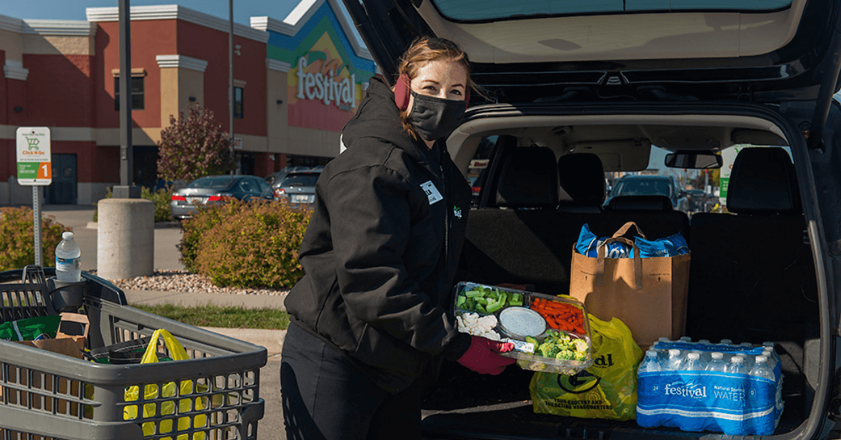woman placing groceries in car