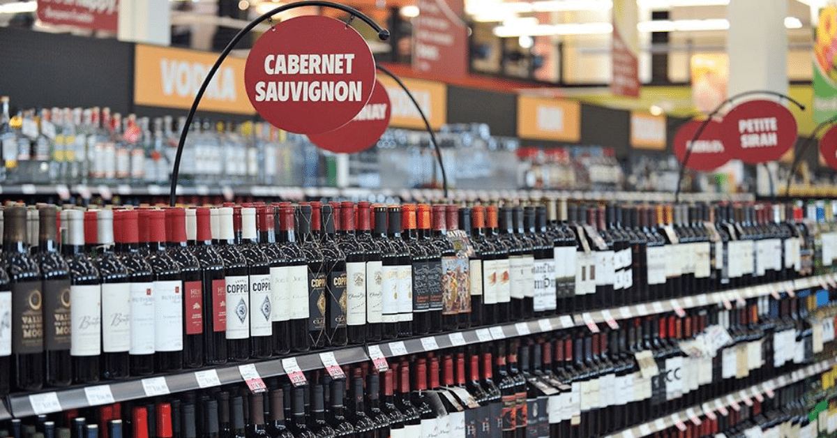 Aisle of various red wines in a grocery store