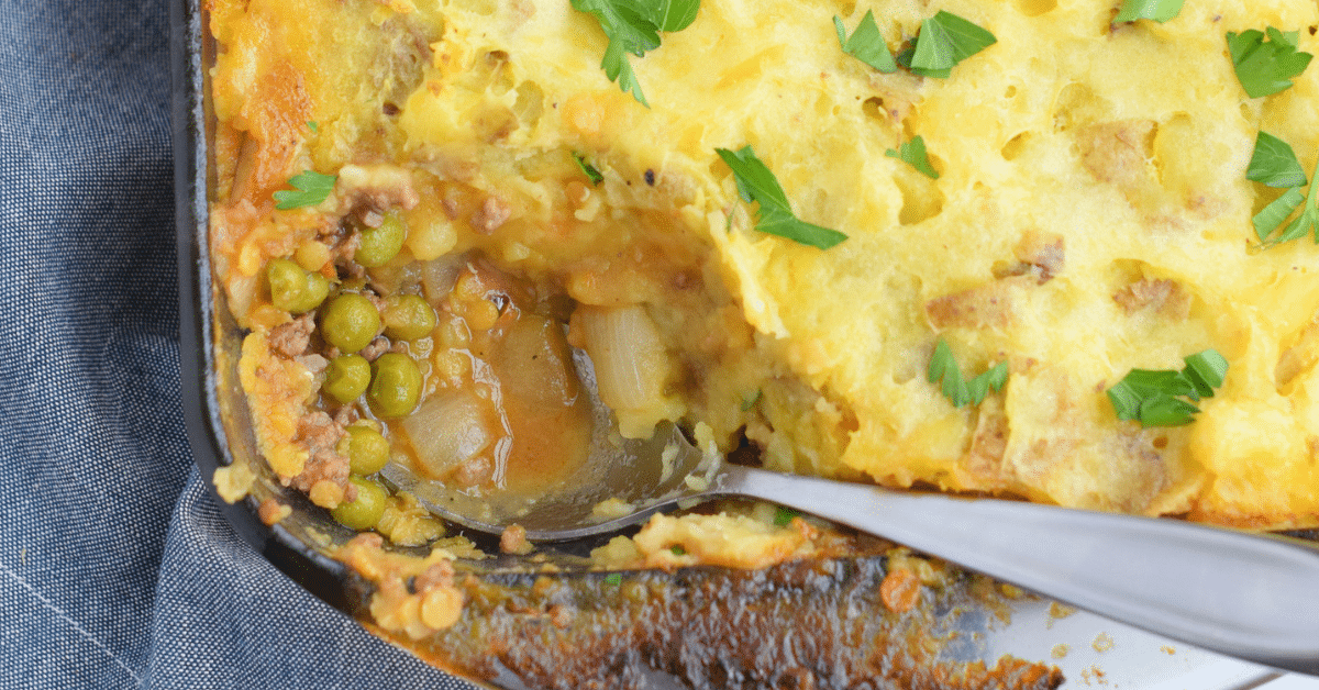 Lentil Shepherd's Pie topped with parsley in a glass baking dish