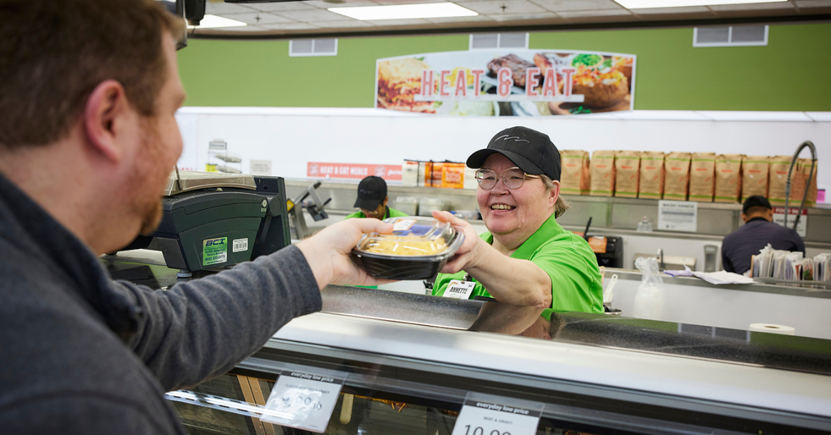 Associate handing product to guest over counter