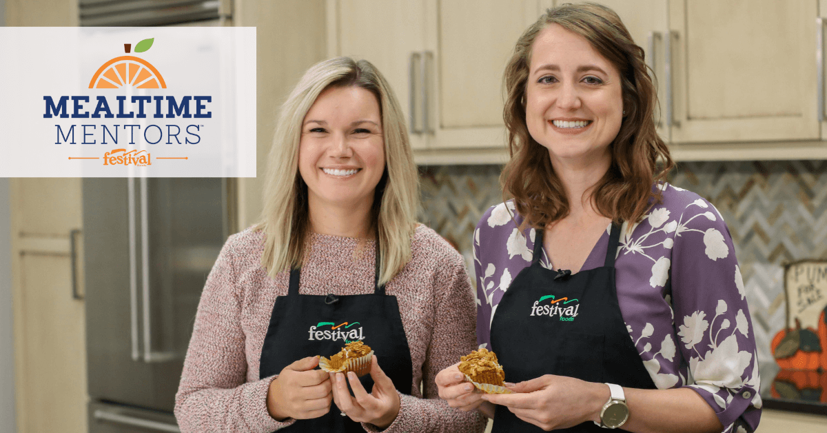 Image of two women holding muffins in a kitchen